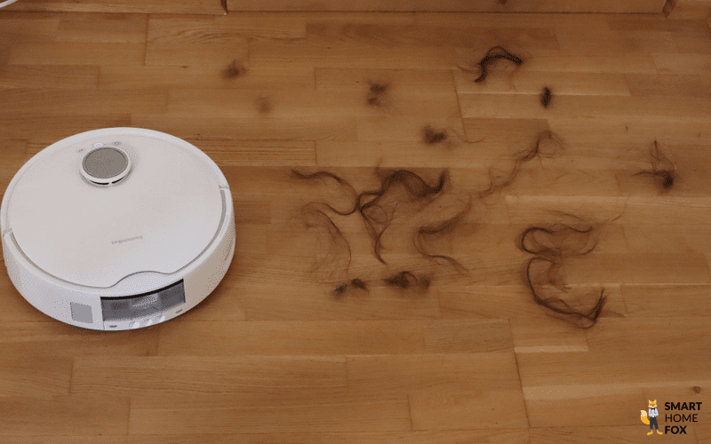 Haare werden beim Test des SwitcHbot S10 auf dem Boden verteilt.